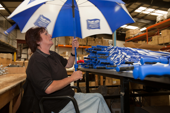 Woman holdin open umbrella in factory