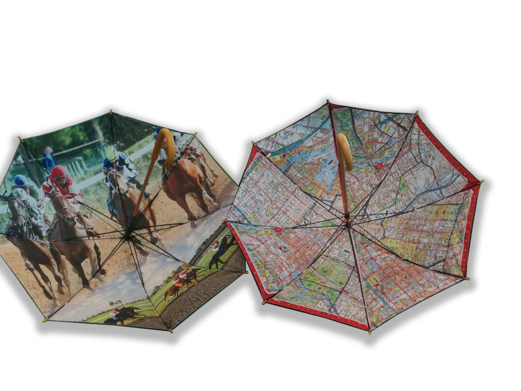 two open umbrellas one with horses racing on the inside and one with a map across the inside of umbrella