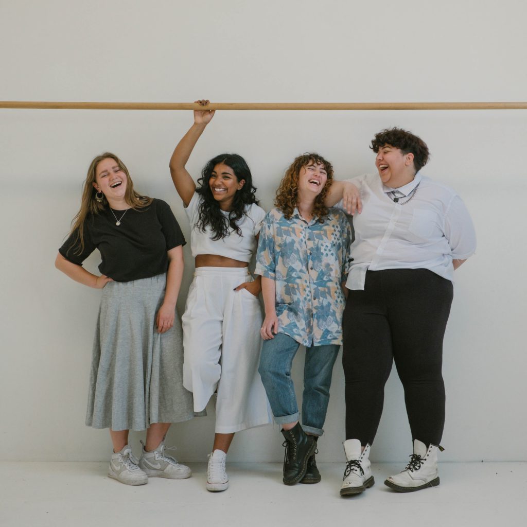 four women standing against a white background employee engagement ideas