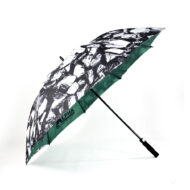 side view of open large golf umbrella with black and white print on outside panels and green on inside