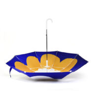 upside down umbrella with blue background and yellow flower on the inside of the umbrella. The umbrella has a white handle.
