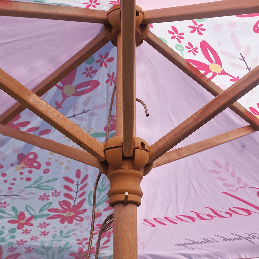 branded parasol with pink panels and wooden ribs show close up on the inside panels