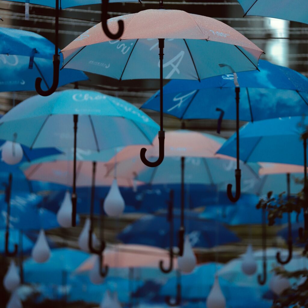 blue and pink umbrellas hanging from a ceiling