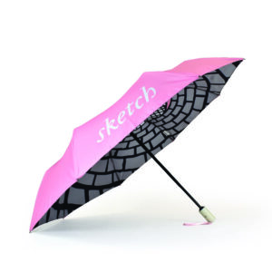 small folding umbrella with pink outside panels and black and white dynamic print on inside umbrella panels