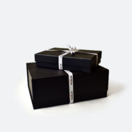 black gift boxes for luxury branded merch with printed branded ribbon