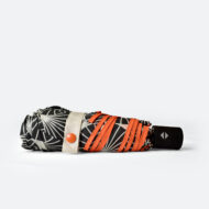 side view of folded umbrella with printed tie wrap and Pantone matched orange popper for C-suite luxury branded merchandise