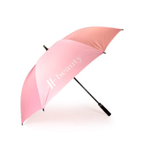side view of open pastel pink premium branded umbrella with white Harrods logo print on one panel