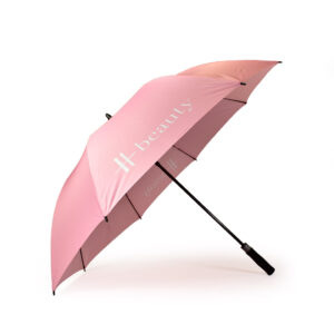 side view of open baby pink premium branded umbrella with white Harrods logo print on one panel