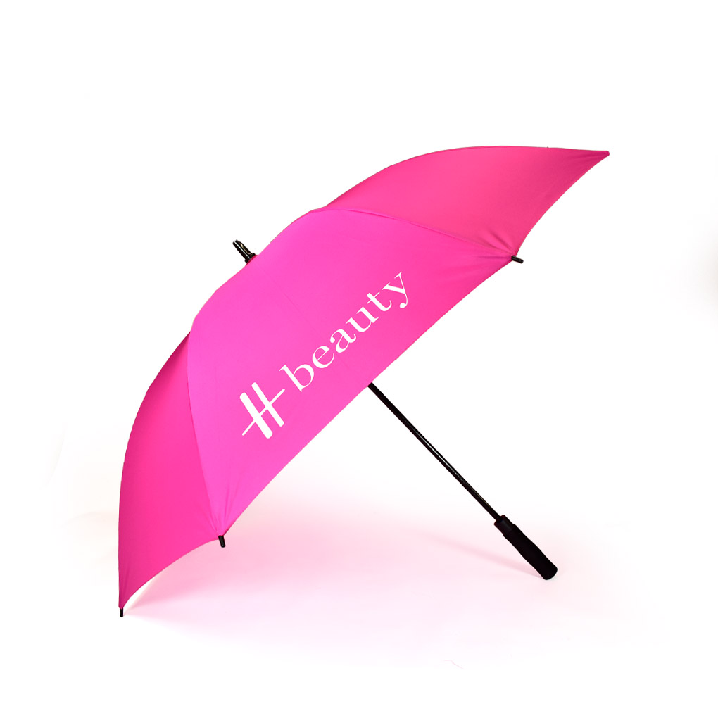 side view of open hot pink premium branded umbrella with white Harrods logo print on one panel